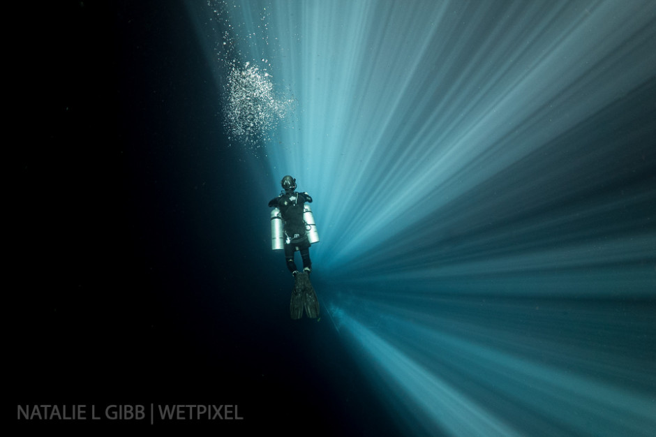 Diver Rory O'Keefe descends though 70-meter tall light beams at Cenote Xkail, a sinkhole in Yucatan State. 