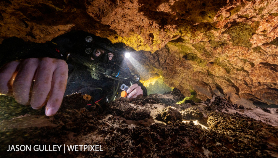 Cave diver and science volunteer Tim Senkovitch collects mineral deposit samples for a group of non-cave diving scientists who are waiting for him on the surface.