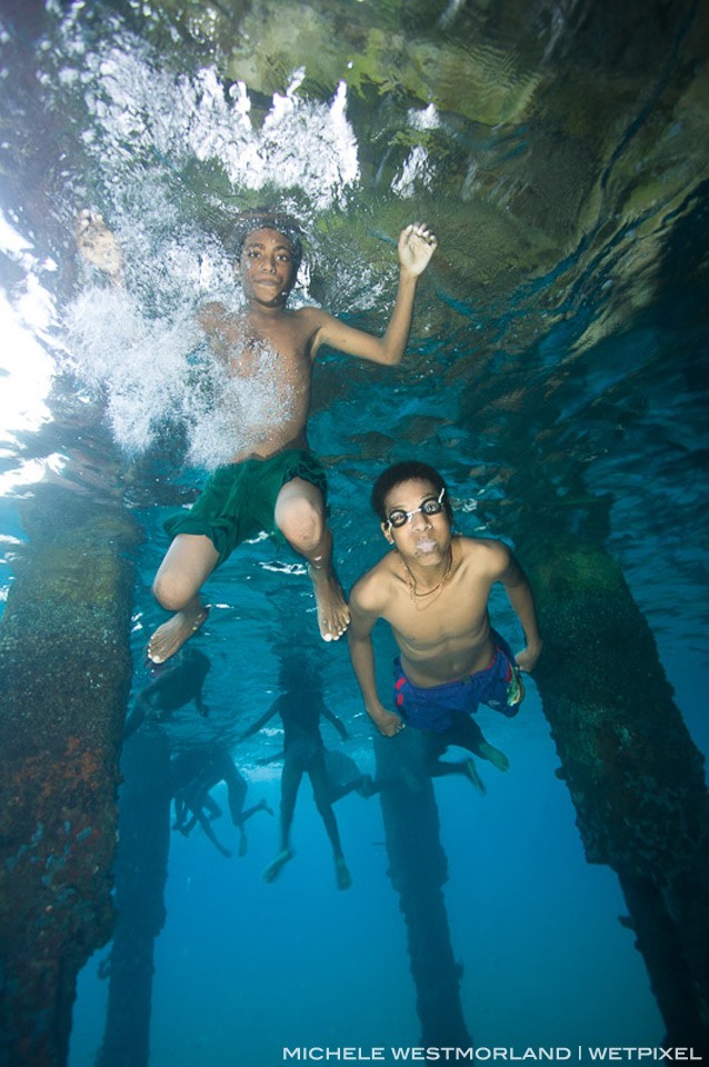 Boys jumping and swimming under Jonny's Jetty, Kokopo/Rabaul, Papua New Guinea