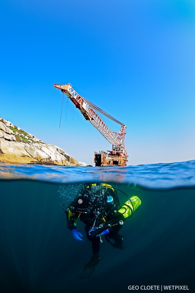 Diver descending while the crane of The Boss 400 towers above.